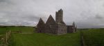 Irland. Verfallenes Haus auf grüner Wiese vor regnerischem Hintergrund.