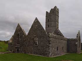 Ruine in Irland bei Regenwetter auf grüner Wiese: